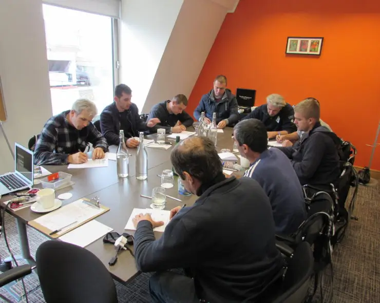 Site managers sitting at table completing their theory section of leading edge training course