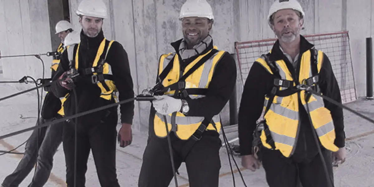 Workers demonstrating how to wear the correct Working at Height Equipment