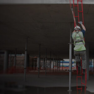 Worker wearing height safety gear climbing safely down a rescue ladder