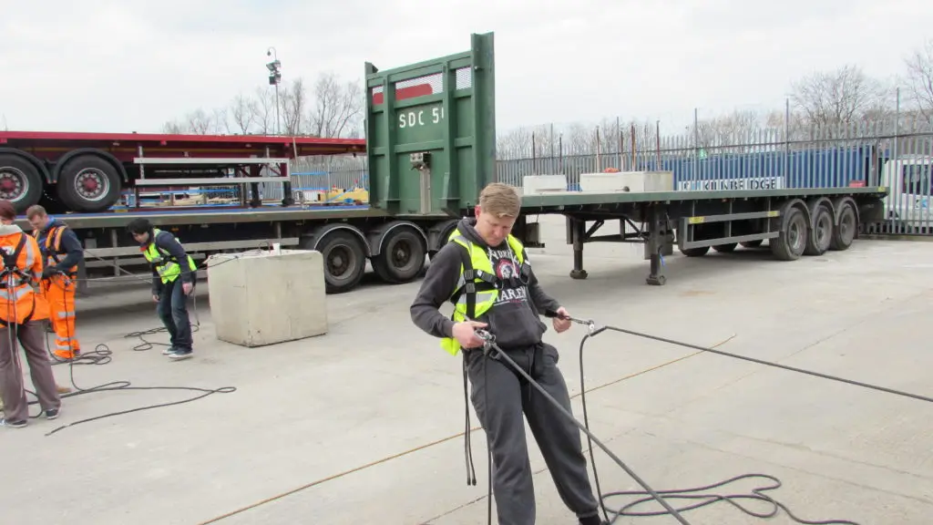 Operative during fall arrest safety equipment training weaing hi-vis, harness and lanyard.