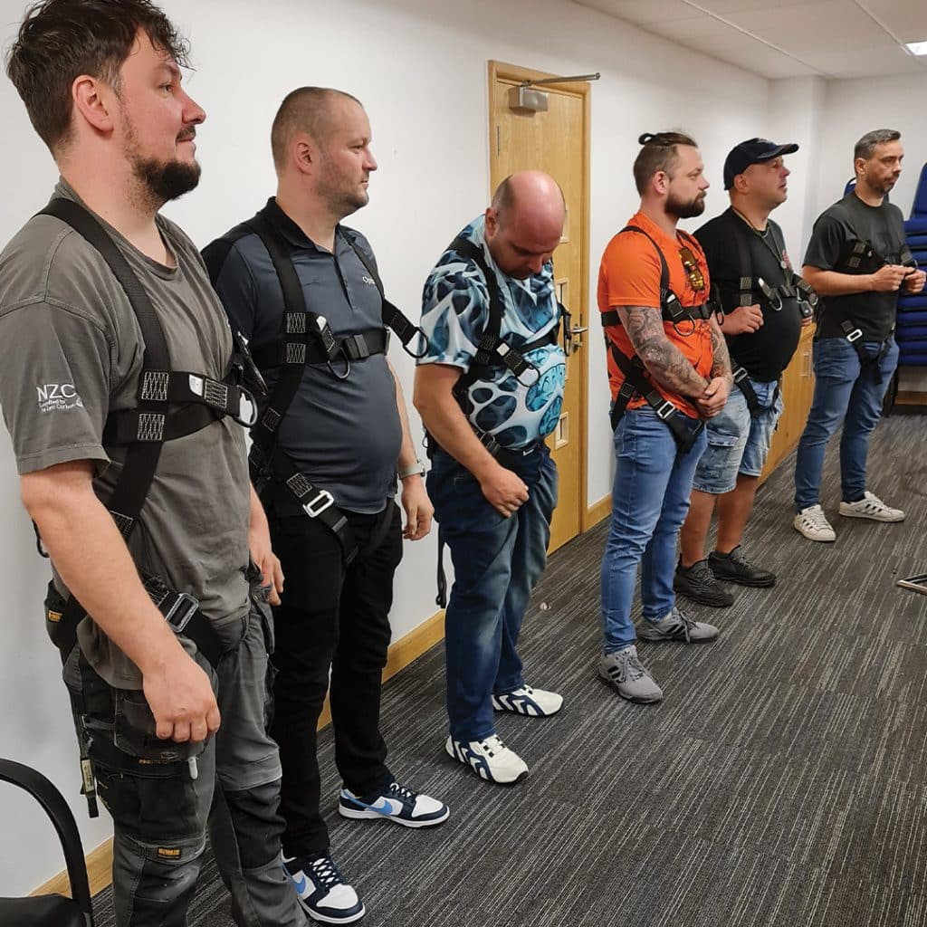 Male trainees wearing a harness